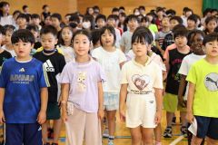 終業式で合唱する児童ら（午前８時５０分ごろ、長尾悦郎通信員撮影）