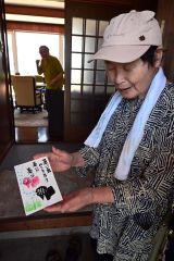 手作りの絵はがきを渡して暑さ対策を呼び掛ける田西さん（写真右）