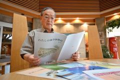 ピースネット・メムオロがこれまでに発行してきた「わたしの戦争体験記」を見つめる高橋代表