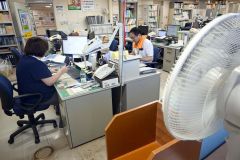 扇風機を回し、首にタオルなどを巻きながら業務に励む十勝総合振興局の職員（２４日午後４時５０分ごろ）