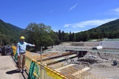 作業が中断され、建設機械などがない現場の状況を伝える石田課長（２３日、帯広市内の十勝幌尻岳の土木工事現場で）