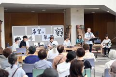 観客の前で演奏している（右から２人目）水川さん、（右から３人目）岩野代表ら