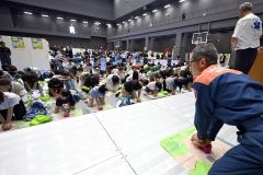 消防署員の実演などを見ながら心臓マッサージを模擬体験する参加者（２６日午前１０時ごろ、須貝拓也撮影）
