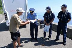 サーファーに水難事故防止を呼び掛ける関係者