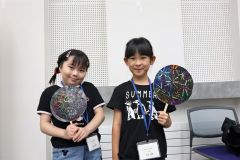 完成したうちわを手にする西尾さん（右）と平塚さん（左）