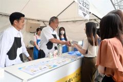 来場者に牛乳を販売する樽井会長（中央）