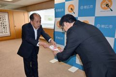 米沢市長に目録を手渡した福原さん（左）