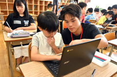 帯広柏葉生（右）に勉強を教えてもらう児童（左）