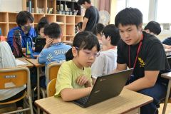 帯広柏葉生（右）に勉強を教えてもらう児童（左）