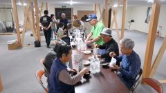 広尾町音調津の避難施設で備蓄された非常食による夕食を済ませる地域住民ら。婦人防災クラブのメンバーたちが率先して準備に当たった（７月３０日午後６時１０分ごろ）