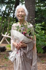花束を手に笑顔を輝かせる松本さん（須貝拓也撮影）