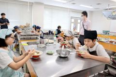 完成した冷やし担々麺を試食する児童ら