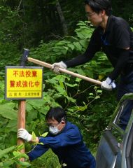 「不法投棄　警戒強化中」を訴える啓発看板を設置する町職員