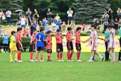 準決勝で北海道コンサドーレ札幌Ｕ１２を破った幕別札内ＲＥＤ（赤色のユニホーム）。試合後、両チームの選手が握手を交わす
