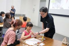 講師の竹内さん（右）とソーラーハウス作りに挑戦する親子ら