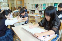 高校生の指導を受けながら、勉強に取り組む児童ら