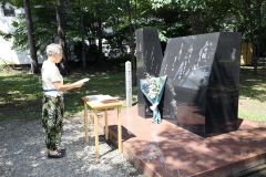 中城ふみ子の歌碑の前で自作の短歌をささげる吉田会長
