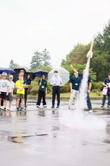 白煙とともに勢いよく上昇するロケットを見守る子どもたち