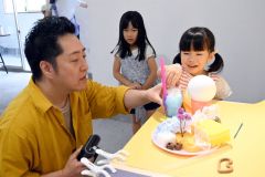 アイスクリームや飲み物をイメージした作品をつくったこどもと鈴木さん（左）