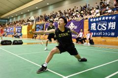 【男子個人戦ダブルス１回戦】第１ゲーム、帯大谷の櫻田琉晟（手前）がシャトルを打ち返す。左後方は若林多辰樹（金野和彦撮影）
