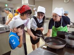 ガスコンロでの調理を体験する参加者