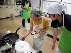 ガスコンロでの調理を体験する参加者