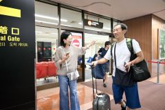 出迎えた家族や知人の出迎えを受け笑顔を見せる乗客たち（９日午前９時半ごろ）