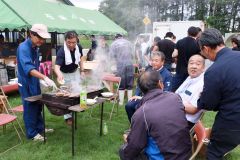 焼き肉を囲んで歓談する参加者ら