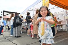 ゆでたてのスイートコーンを手に笑顔の子ども