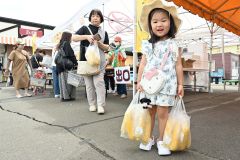 袋いっぱいのスイートコーンにうれしそうな子ども
