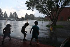 この日は上士幌町でも夕方に雨が降った。大粒の雨でできた水たまりにはしゃぐ子ども（１２日午後５時５分ごろ、北村里沙撮影）