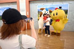 日高山脈の写真の前で記念写真を撮る来場者ら