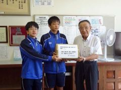 生徒代表に熱中症対策ゼリーを贈呈する大井会長（右）＝大樹町社会福祉協議会提供