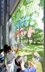 クレヨンで窓ガラスに日高山脈の動植物を描く子どもたち（１２日、塩原真撮影）
