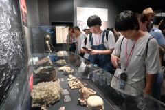 展示資料を見つめる北橋さん（右から２人目）