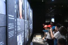 スマートフォンに展示資料を収めながら見つめる北橋さん（左から２人目）
