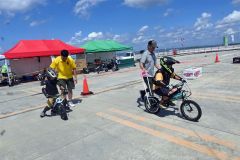 補助バー付きの電動バイクを体験する子供たち。すぐに乗れるようになった(13日)