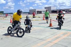 スタッフの指導を受け、電動バイクでコースを走行する子供たち(13日)