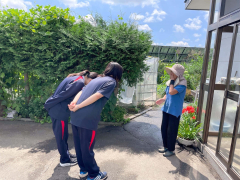 地域の人から花をもらい、お礼する鈴木さん、小椋さん（「モモんが」提供）