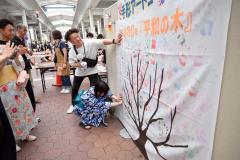 平和への思いを込めて手形を付ける来場者