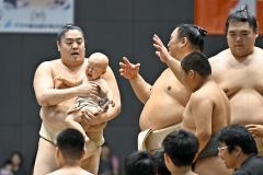 おむつの上にまわしを付けて幕内・一山本（後志管内岩内町出身）にだっこされる赤ちゃん