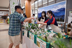 空港に訪れた観光客らに十勝産野菜などを販売する生徒たち（１７日午前９時半ごろ）