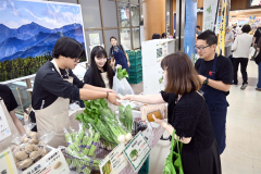 空港に訪れた観光客らに十勝産野菜などを販売する生徒たち（１７日午前９時半ごろ）