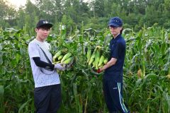 (写真左から)本別町の嶋崎農場でスイートコーンの収穫体験をした松岡さんと早野さん