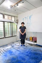 「銀河鉄道の夜」に合わせた書作品に、油彩作品を描き足している篠田さん