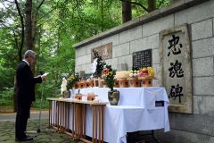 忠魂碑に向かって祭文を読み上げる植田会長