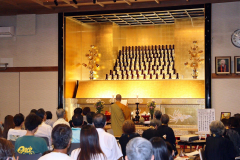完成した「永代供養　金色堂」の前で落成式を行う石橋住職と参列者