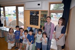 似鳥財団の助成金で設置されたエアコンと子どもたち。左端は松浪事務長、右から２番目が柿崎さん