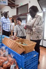 愛菜屋で十勝の作物を手に取るササカワ・アフリカ財団の外国人スタッフ