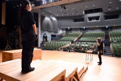 舞台の演出や効果などについてホール技術スタッフから学ぶ生徒ら